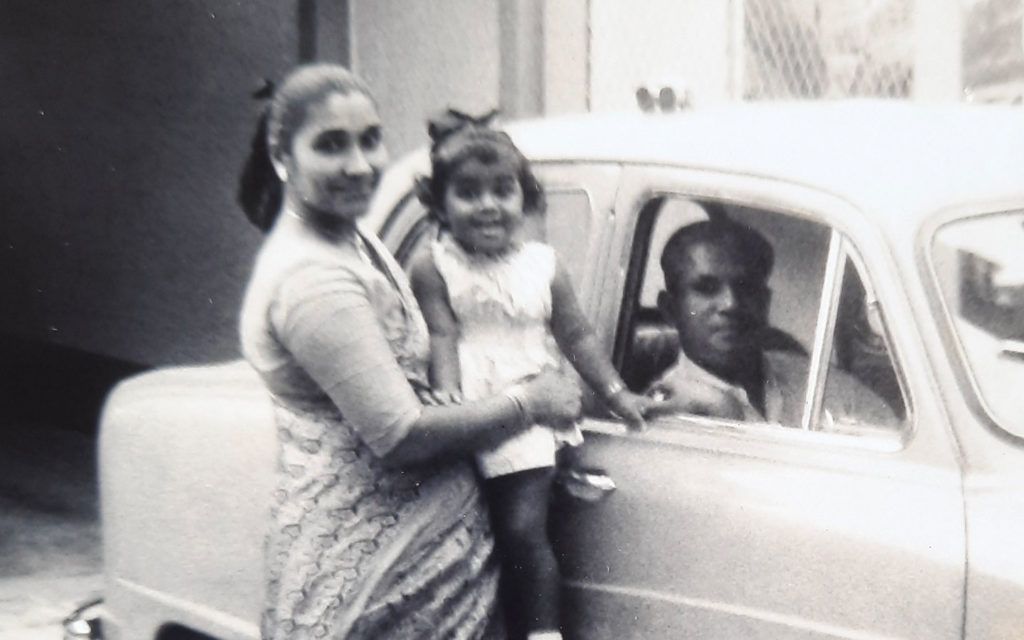 A young girl carried by her mother standing next to a care